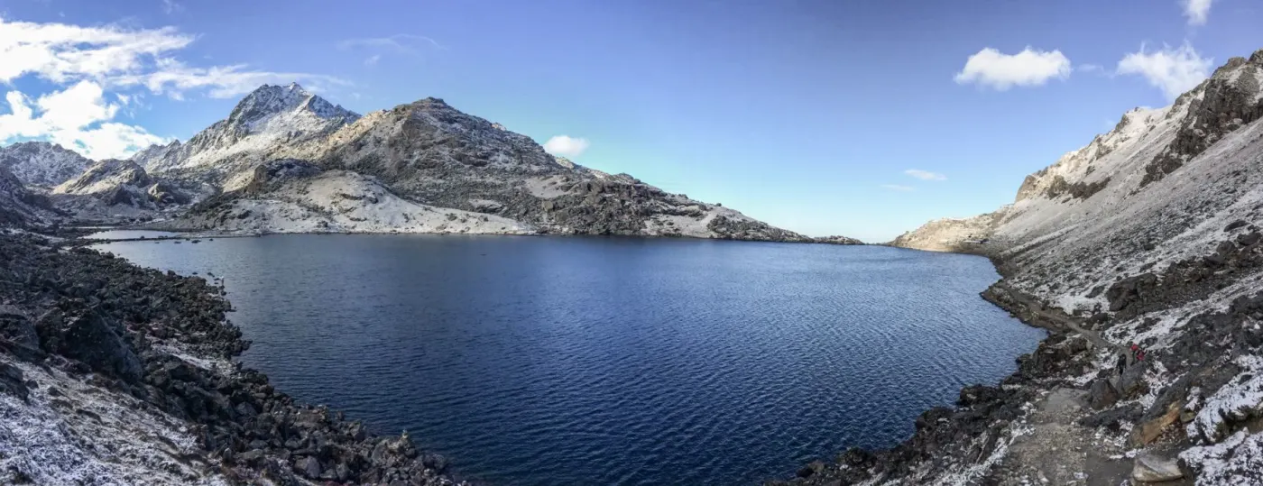 A deep blue alpine lake below rocky slopes